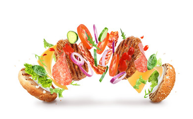Delicious burger with different flying ingredients on white background