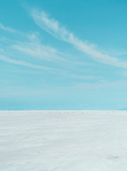 SALT. Salt Flats Uyuni Bolivia. Desert like Landscape with blue sky, clouds and empty space. Holiday, vacation, adventure, freedom. Copy space. Car tyre marks on road.