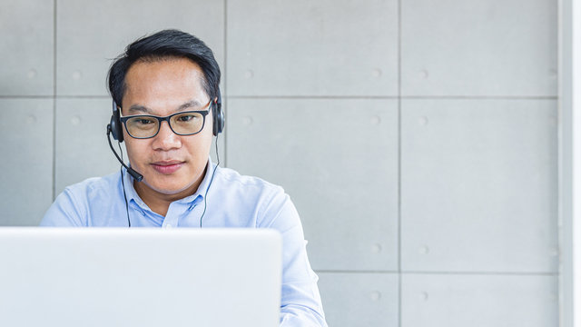 Asain Male Operator Taking A Call From Customer. Call Center Support Service.