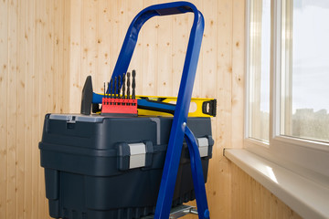 box with tools for the repair of housing stands on a portable ladder, close-up