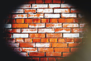 A brick wall in the dark with a beam of light in the center.Concentration on the object in the center