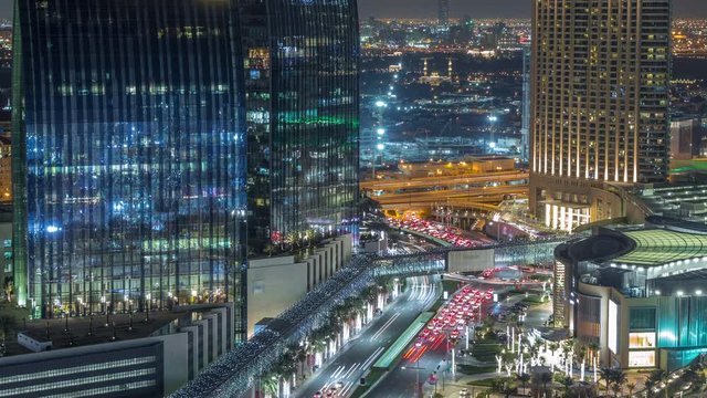 Dubai downtown street with busy traffic and skyscrapers around night timelapse. Modern road and urban buildings with mall aerial view. Sheikh Mohammed bin Rashid Blvd