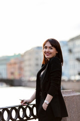 Woman in black pantsuit walks on promenade