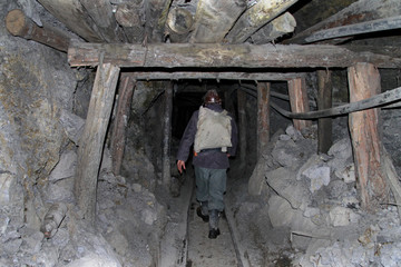 Fototapeta na wymiar A miner walks through a dangerously unstable shaft of a mine in Cerro Rico.