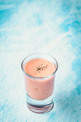 Andalusian gazpacho in shot glass with bluish background