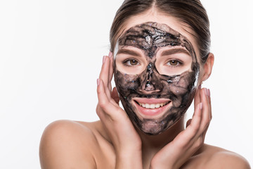 Young beautiful woman in a mask for the face of the therapeutic black mud. Spa treatment