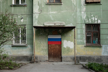 old Soviet house with the flag of the Russian Federation on the door
