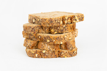 Bread pieces for sandwiches laying in pile. Delicious loaf and pastry with poppyseeds and cereals isolated on white background. Studio shot. Side view. Homemade bakery and cooking at home concept
