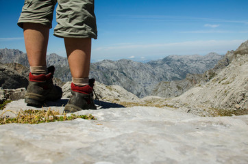 hiker feet high up in the picos de europa mountains in summer with blue sky