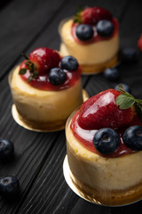 French desserts with berries on a dark wooden background