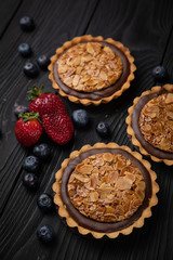 French desserts with berries on a dark wooden background