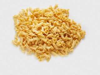 uncooked pasta campanelle on white background