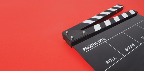 Fototapeta na wymiar Black Clapperboard or movie slate on red background.it is used in video production and film industry .