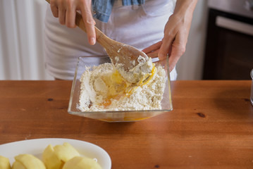 A beautiful woman bakes a homemade apple cake in her home kitchen
