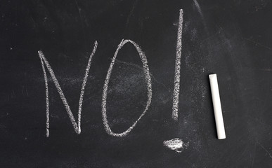 inscription in chalk no on black chalk board, concept of denial