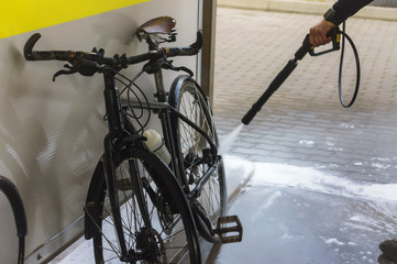 A black bicycle is stained with mud. Dirty black bike. Wash a black bike out of the dirt. Wash your...