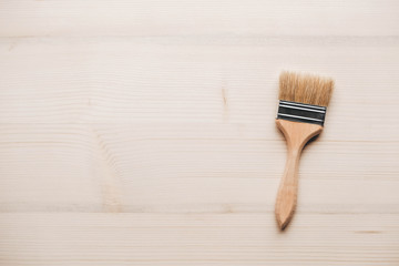 Paint brushes with a wooden handle and natural bristles on a wooden background. Repair concept. Top...