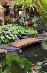 Fototapeta na wymiar Bamboo bridge over pond in patio garden design