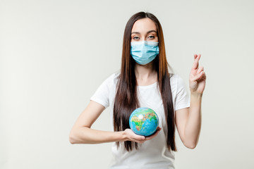 woman praying for planet earth globe wearing mask isolated on white background