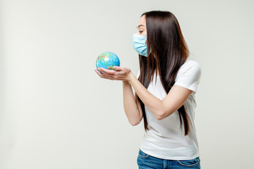 woman looking at planet earth globe wearing mask isolated on white background