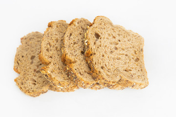 Four sliced pieces of cereal bread laying at table. Fresh homemade loaf cutting for eating isolated on white background. Studio shot. Top view. Cooking and baking at home concept