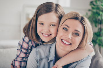 Closeup photo of domestic attractive blond lady mommy daughter comfy couch hugging piggyback stay home quarantine spend weekend together overjoyed best friends living room indoors