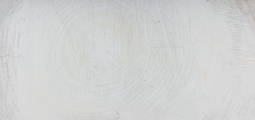 Detail texture of tree rings painted white. Round cut slice of a wooden log. Textured natural surface with rings and cracks.