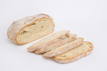 Cut fresh wheat bread part and slices. Closeup shot. Isolated object on white background. Homemade food or breakfast concept