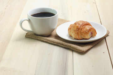 Croissant and coffee  isolated on wood table