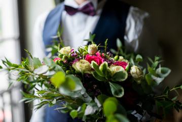groom holds a wedding bouquet