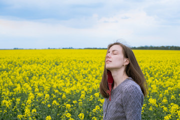 portret of a girl took off her mask and feels free of carotene addiction among the rapeseed...