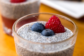 mango mousse with berries and powdered sugar on a wooden table