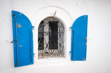 a window of the Prophet Elias Holy Temple, an orthodox church is standing up the hill in a greek landscape