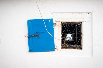 a window of the Prophet Elias Holy Temple, an orthodox church is standing up the hill in a greek landscape