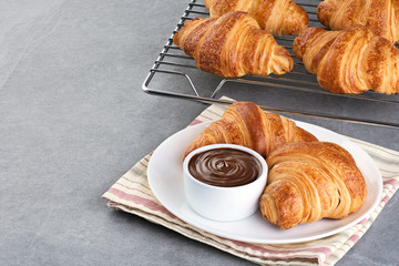 Croissants and chocolate butter on a gray background.