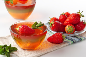 Fruit jelly with strawberries on a white table