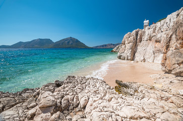 among the rocks, a little white sand beach and the turquoise water of the Mediterranean sea