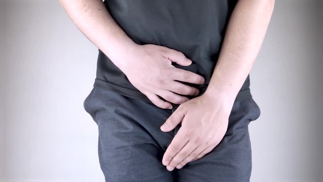 Man front view. Pain in the groin and bladder. The concept of pain in men as a result of prostatitis, inflammation of the bladder or genitourinary system. Frequent urination.