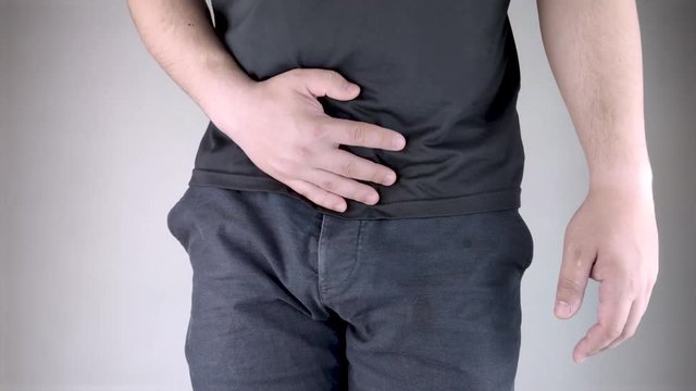 Man front view. Pain in the groin and bladder. The concept of pain in men as a result of prostatitis, inflammation of the bladder or genitourinary system. Frequent urination.