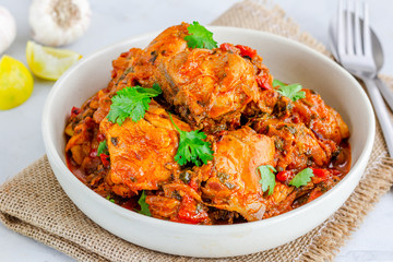 Fototapeta premium Indian Chicken Peshawari, Spicy Indian Style Chicken Curry Garnished with Lemon and Cilantro, Close Up Indian Food Photo 