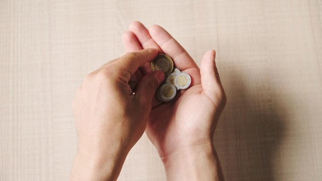 Man counts coins Mexican peso. Poverty and financial crisis in Mexico. Top view. Close up