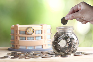 Savings money coins  with sunlight and green background