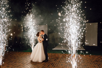 Wedding fireworks. Wedding couple bride and groom dance during a fire show. Full-length photo at night