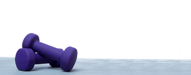 Small blue dumbbells on grey wooden floor. Online workout concept