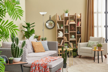 Brown living room, botanic interior style, grey sofa bookshelf and lamp concept.