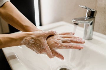 female hands wash with soap in the sink with water