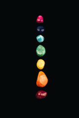 Chakra stones, crystals in a row on black background.