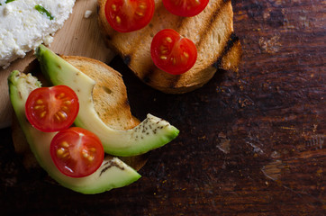 homemade cheese with onions and garlic close-up, sandwich with avocado and cherry tomatoes