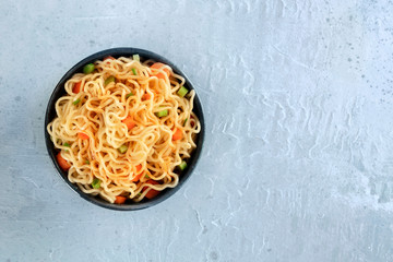 Instant noodles with carrot, scallions, and a sauce, a vegetable soba bowl, shot from the top with a place for text