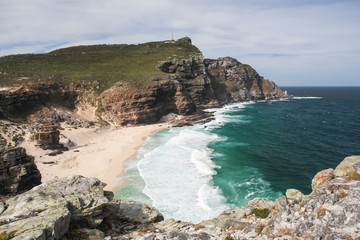 Rocks, coast, beach and lighthouse at the Cape of Good Hope. Storm on the beach.
